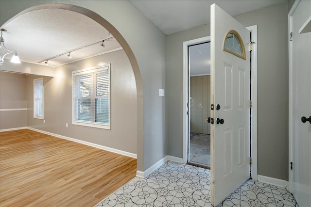 foyer featuring a textured ceiling, track lighting, and light hardwood / wood-style flooring