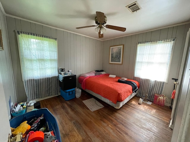 bedroom with ceiling fan, dark hardwood / wood-style floors, and ornamental molding