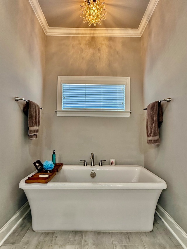 bathroom featuring a tub to relax in, plenty of natural light, and ornamental molding