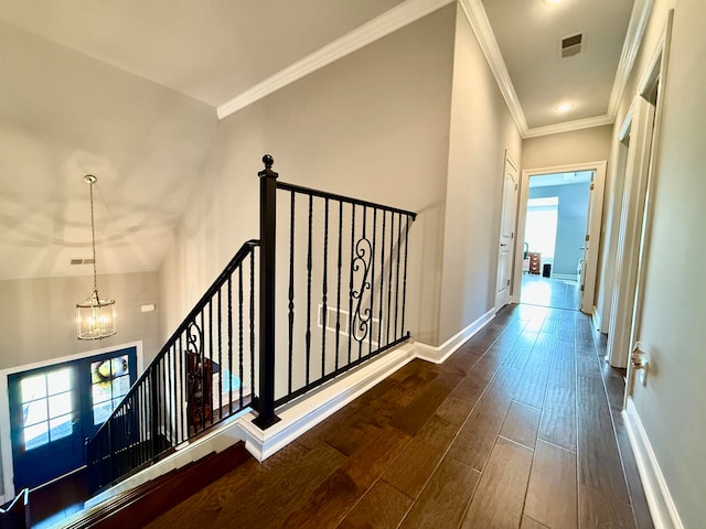 hall featuring a chandelier, dark wood-type flooring, and ornamental molding