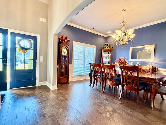 dining area featuring crown molding, dark wood-type flooring, and a chandelier