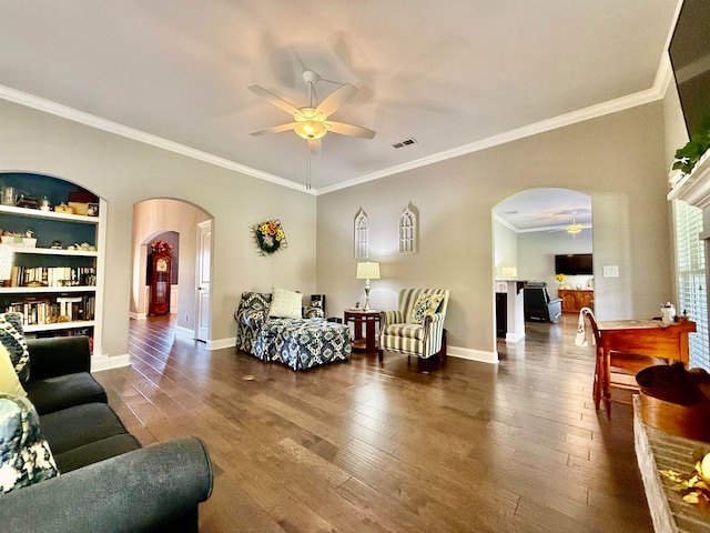 living room featuring hardwood / wood-style flooring, a brick fireplace, ceiling fan, and crown molding