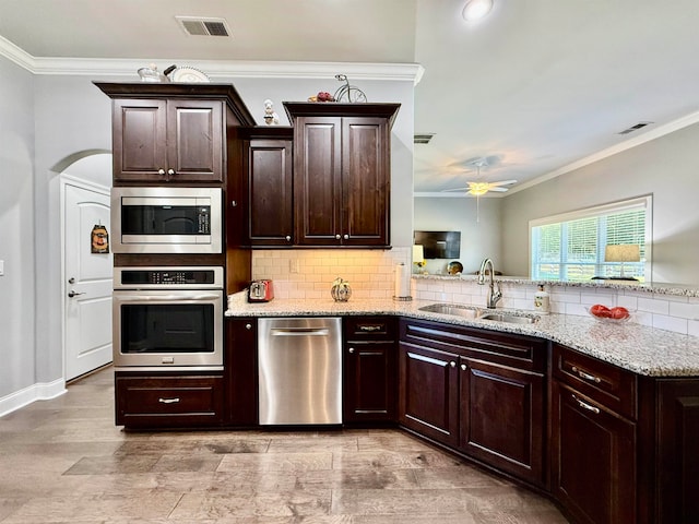 kitchen with crown molding, ceiling fan, sink, and stainless steel appliances