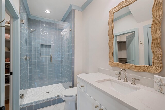 bathroom featuring vanity, toilet, and a shower with shower door