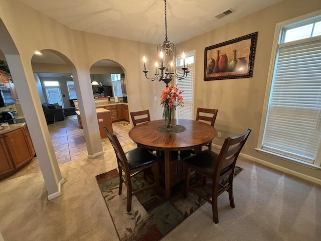 dining space featuring a notable chandelier and light carpet