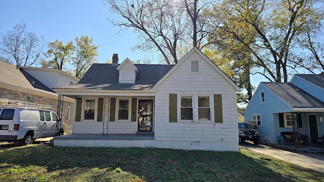 view of front of house featuring covered porch and a front lawn