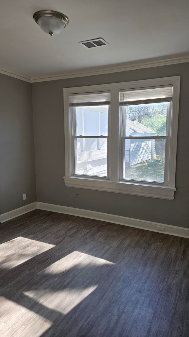 spare room featuring dark hardwood / wood-style flooring and ornamental molding