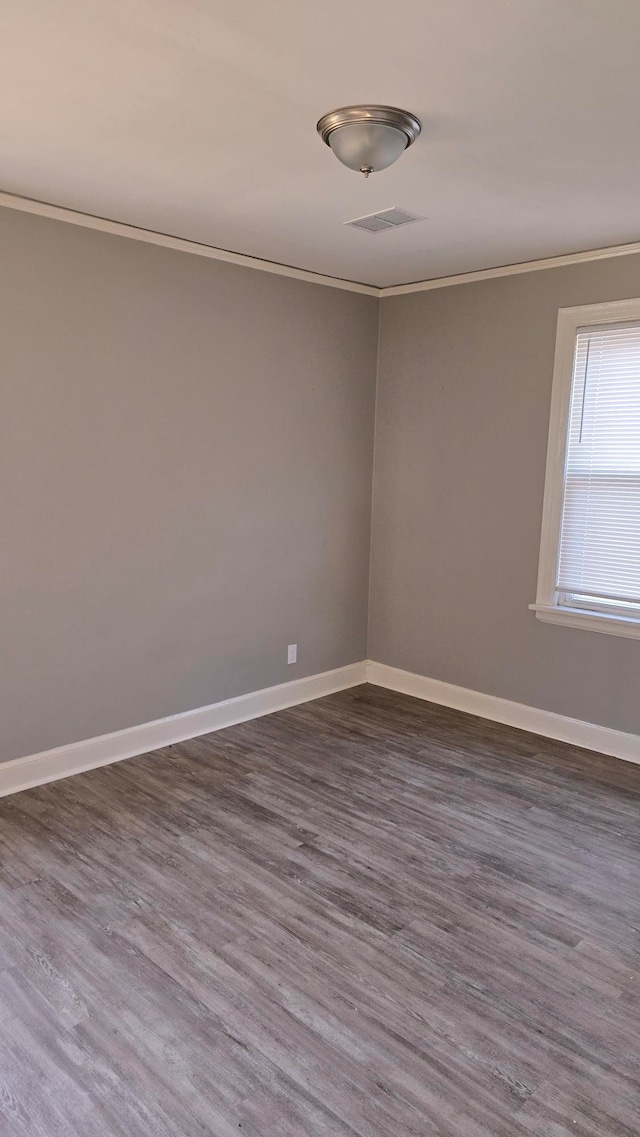 spare room featuring dark wood-type flooring and ornamental molding