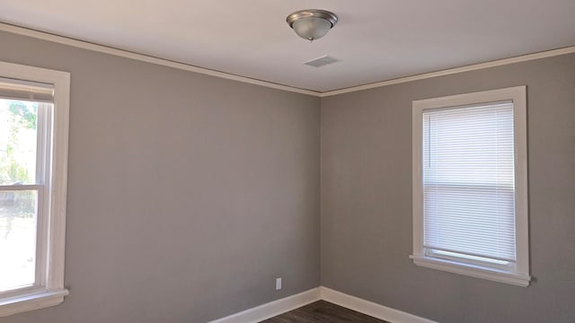 spare room featuring dark hardwood / wood-style flooring and crown molding