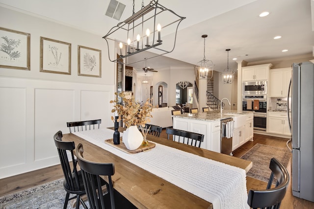 dining room with ceiling fan, sink, dark hardwood / wood-style floors, and ornamental molding