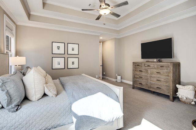 carpeted bedroom with a tray ceiling, ceiling fan, and crown molding