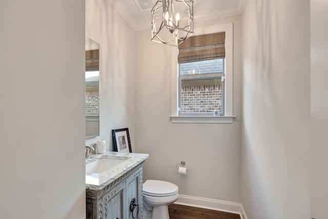 bathroom featuring sink, a notable chandelier, crown molding, wood-type flooring, and toilet