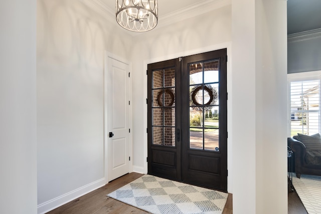 foyer with hardwood / wood-style floors, ornamental molding, french doors, and a chandelier