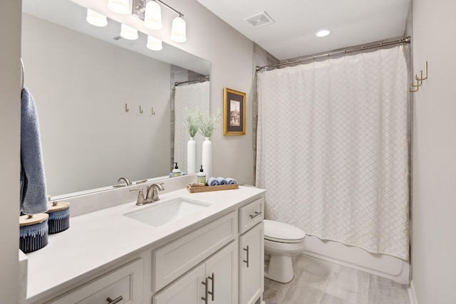 full bathroom with shower / bath combo with shower curtain, vanity, and toilet