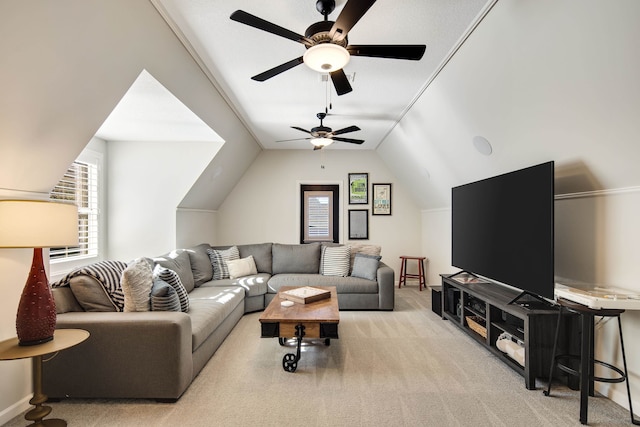 carpeted living room with ceiling fan and vaulted ceiling