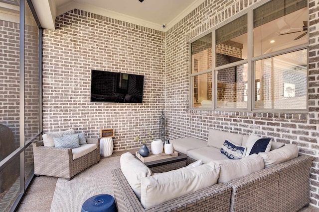 unfurnished living room featuring ceiling fan, crown molding, and brick wall