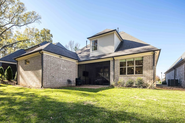 rear view of property featuring a yard, a sunroom, and central air condition unit