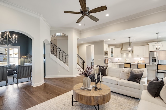 living room featuring dark hardwood / wood-style floors, ceiling fan, and crown molding