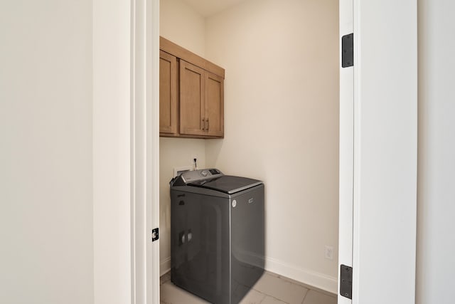 laundry room with cabinets, light tile patterned floors, and washer / clothes dryer