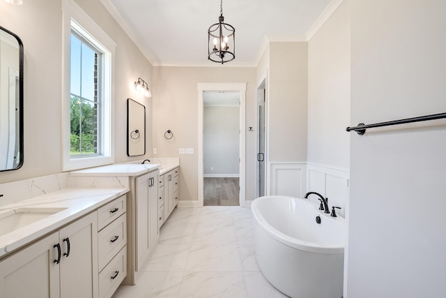 bathroom featuring a bathtub, ornamental molding, vanity, and a chandelier