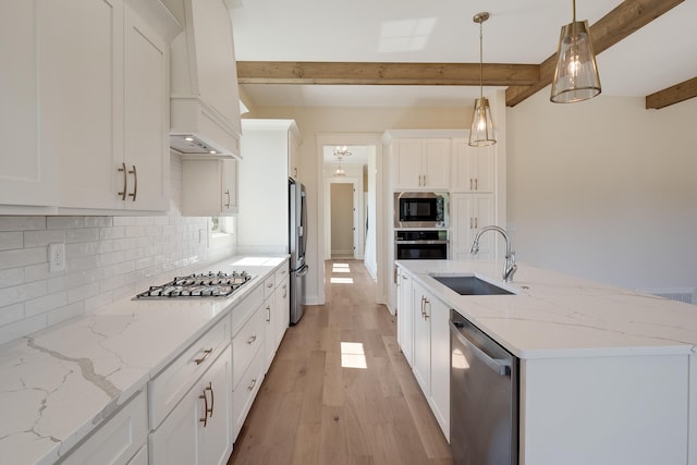 kitchen featuring beam ceiling, sink, pendant lighting, white cabinets, and appliances with stainless steel finishes