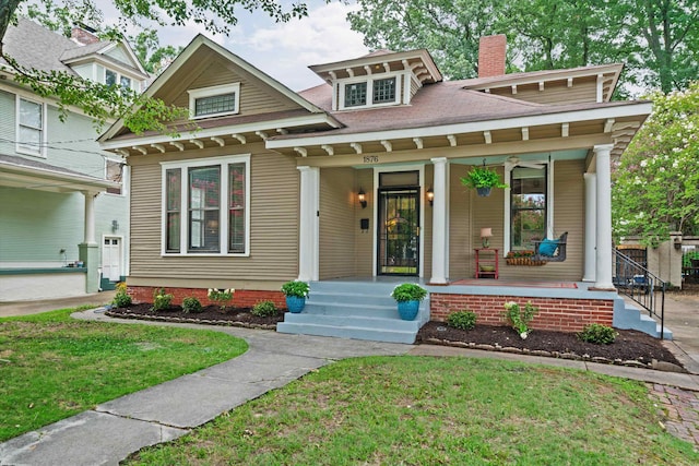 view of front of property with covered porch and a front lawn