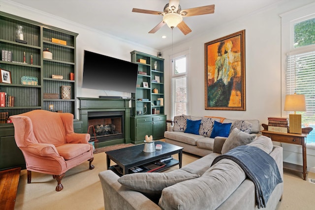 living room featuring hardwood / wood-style floors, ceiling fan, and ornamental molding