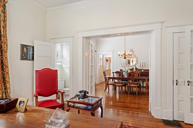 interior space with an inviting chandelier, ornamental molding, and hardwood / wood-style flooring