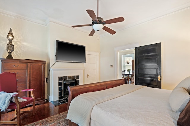 bedroom featuring crown molding, a fireplace, ceiling fan, and dark hardwood / wood-style floors