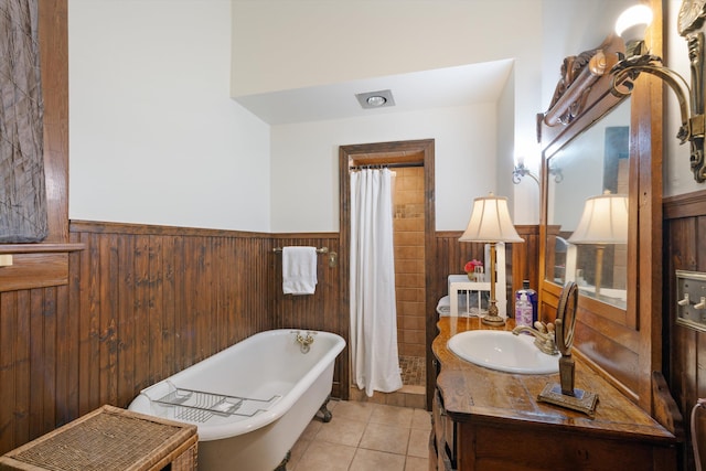 bathroom with a tub to relax in, wooden walls, tile patterned flooring, and vanity