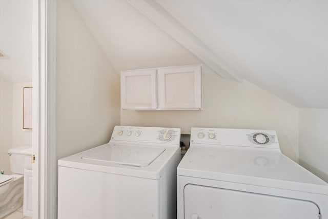 laundry area featuring washing machine and dryer and cabinets