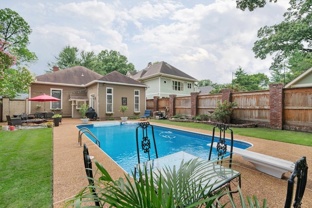 view of pool with a yard, a diving board, and a patio area