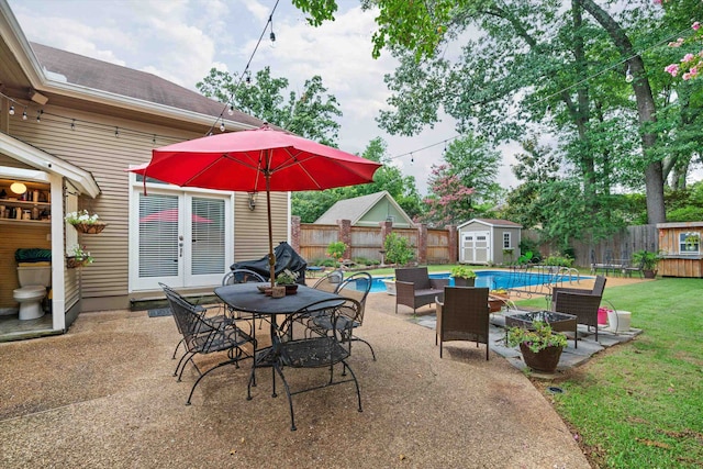 view of patio with a fenced in pool and a storage unit