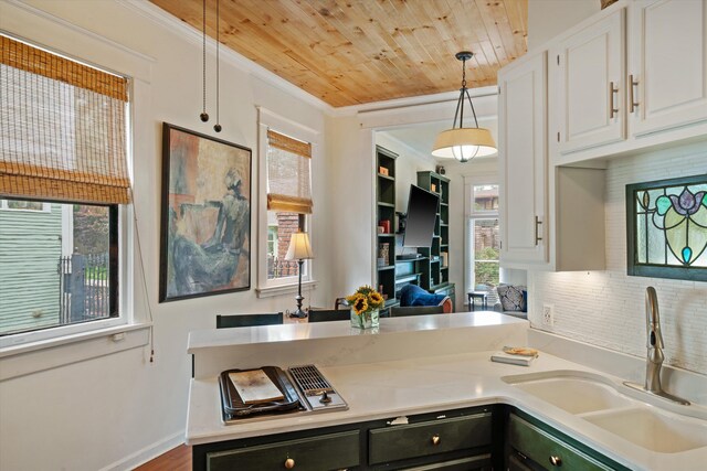 1876 Cowden Ave, Memphis, TN 38104 - kitchen with a sink, wooden ceiling, light countertops, hanging light fixtures, and white cabinets