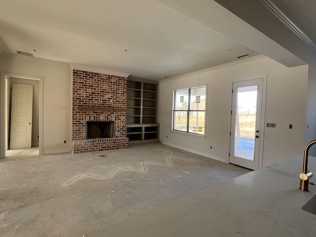 unfurnished living room featuring a brick fireplace, crown molding, and built in shelves