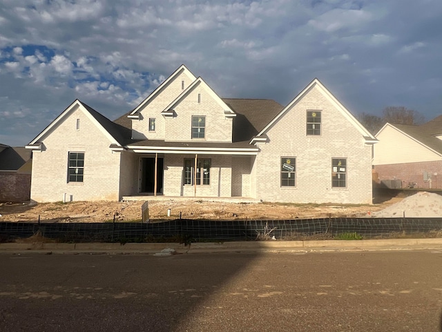 view of front of house with fence and brick siding