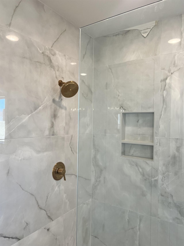 bathroom with a marble finish shower