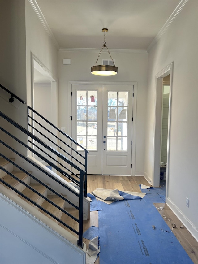 doorway to outside with french doors, crown molding, wood finished floors, baseboards, and stairs