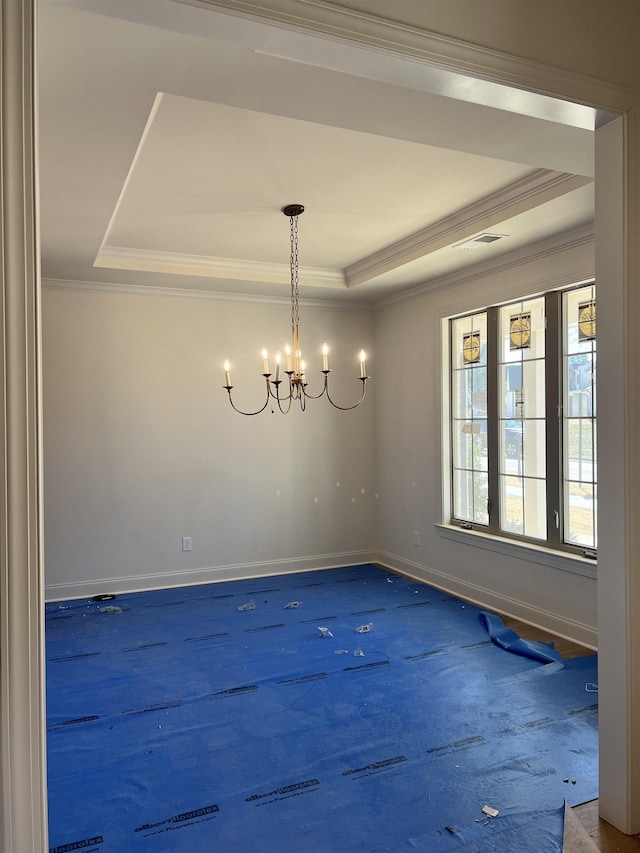 empty room featuring a tray ceiling, crown molding, visible vents, a chandelier, and baseboards