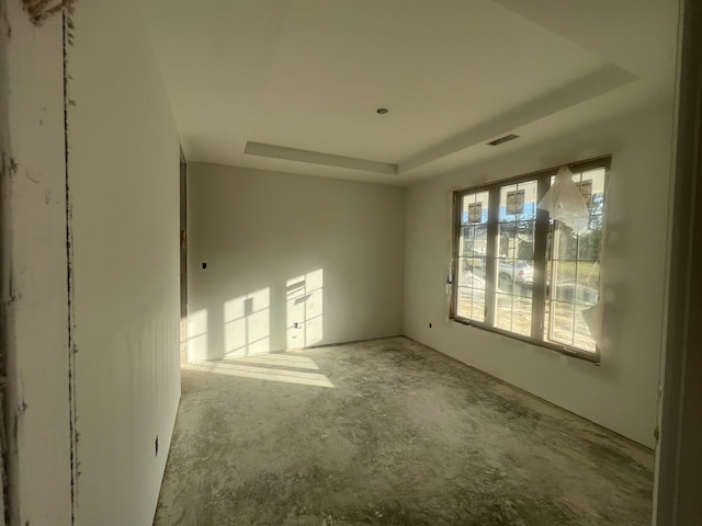 unfurnished room with visible vents and a tray ceiling