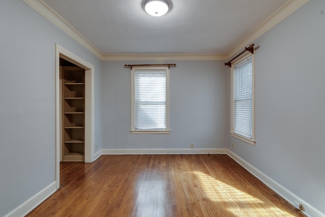 spare room featuring hardwood / wood-style floors and ornamental molding