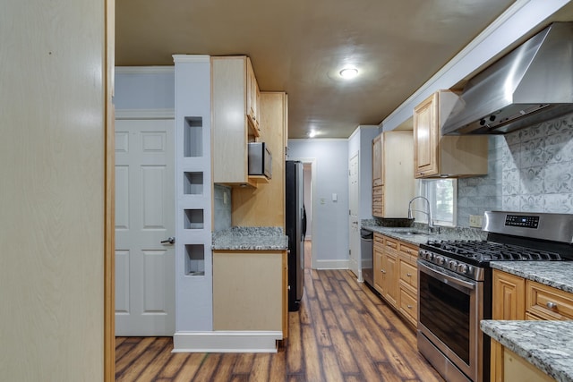 kitchen featuring dark wood-type flooring, wall chimney range hood, crown molding, sink, and stainless steel appliances