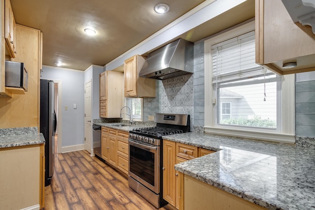 kitchen with sink, stainless steel appliances, wall chimney range hood, dark hardwood / wood-style flooring, and ornamental molding