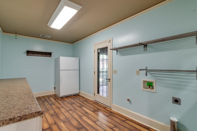 clothes washing area with hookup for an electric dryer, washer hookup, ornamental molding, and dark wood-type flooring