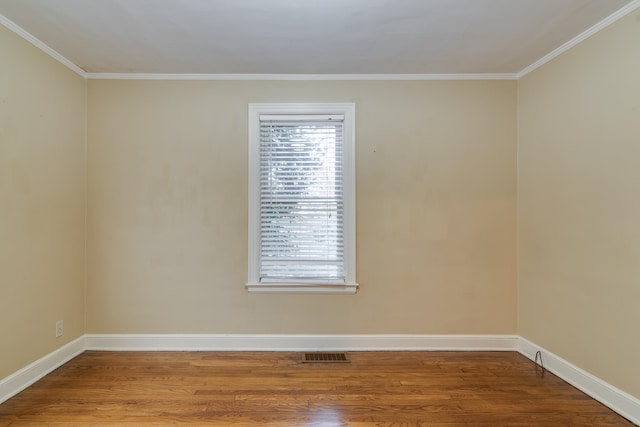 spare room with wood-type flooring and crown molding