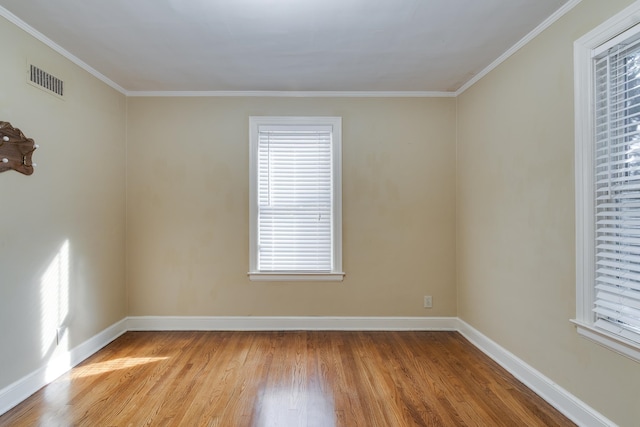 empty room with light hardwood / wood-style flooring and crown molding