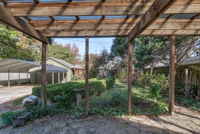 view of patio featuring a pergola, a carport, and a storage unit