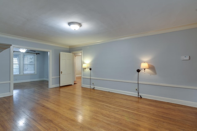 empty room featuring crown molding and light hardwood / wood-style flooring