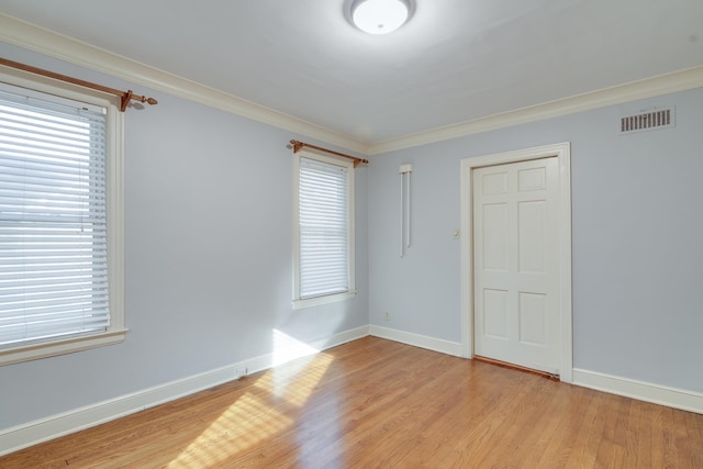 unfurnished bedroom with multiple windows, crown molding, and light hardwood / wood-style floors