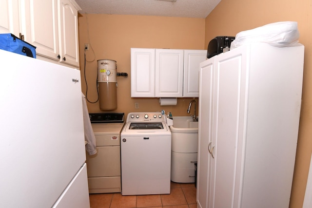 laundry area with separate washer and dryer, light tile patterned floors, cabinets, and a textured ceiling